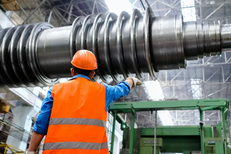 Factory worker on second shift reviewing production equipment